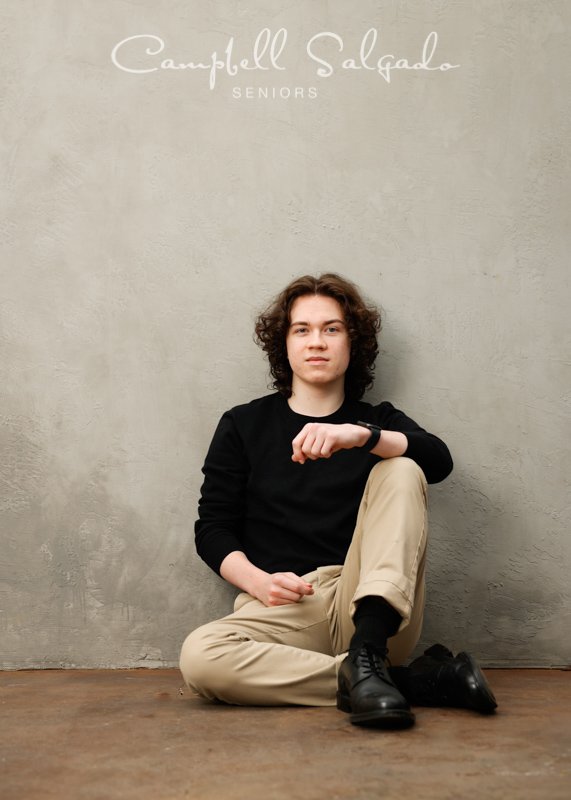  Senior picture of a young man on a modern grey background by high school senior photographers at Campbell Salgado Studio in Portland, Oregon. 