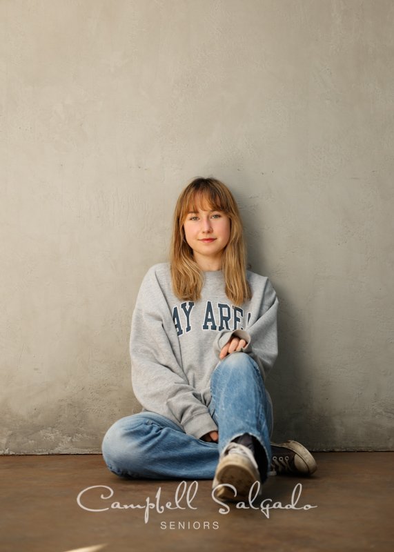  Senior picture of a young woman on modern grey background by high school senior photographers at Campbell Salgado Studio in Portland, Oregon. 