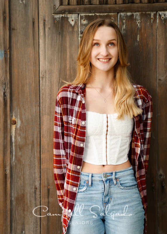  Senior picture of a young woman on a barn doors background by high school senior portrait photographer at Campbell Salgado Studio in Portland, Oregon. 