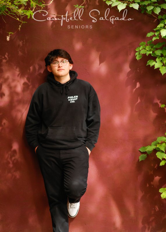  Senior picture of a young man on a plum stucco background by high school senior photographers at Campbell Salgado Studio in Portland, Oregon. 