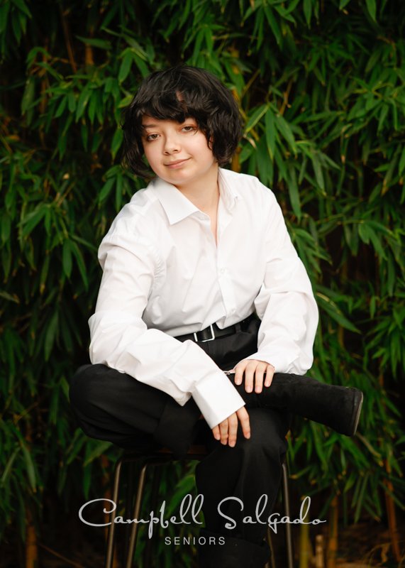  High school senior pictures of a young woman standing in front of a bamboo background by senior photographers at Campbell Salgado Studio in Portland, Oregon. 