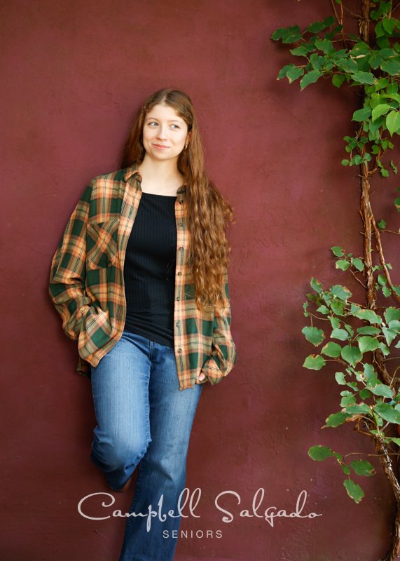  High school senior portrait photography of teen on plum stucco background by senior picture photographers at Campbell Salgado Studio in Portland, Oregon. 