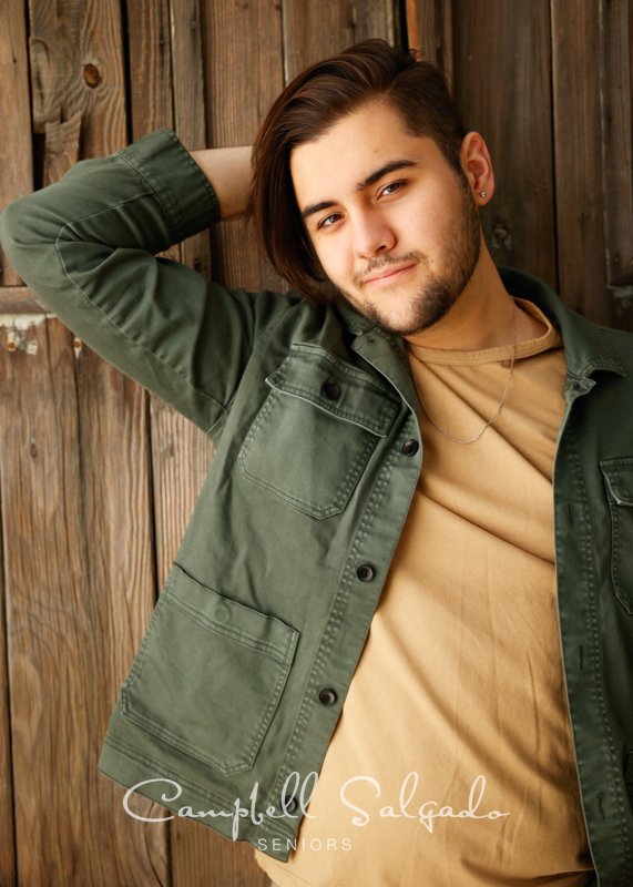  Senior portraits, Portland Oregon of young man in front of a barn door background by high school senior photographer at Campbell Salgado Studio. 