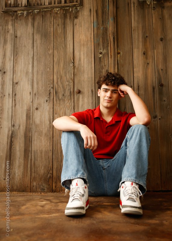  Senior picture of a young man on barn doors background by high school senior photographers at Campbell Salgado Studio in Portland, Oregon. 