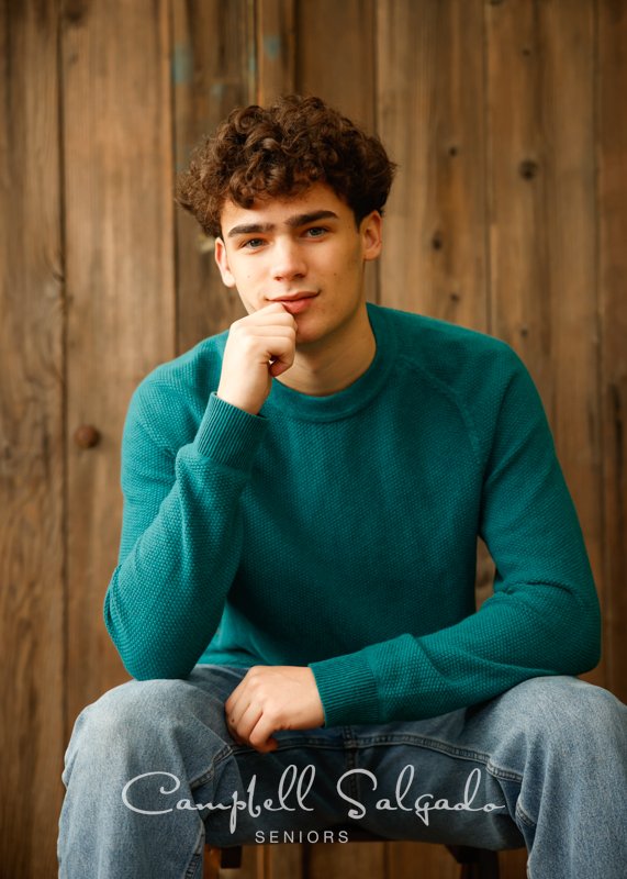  Senior picture of a young man on barn doors background by high school senior photographers at Campbell Salgado Studio in Portland, Oregon. 