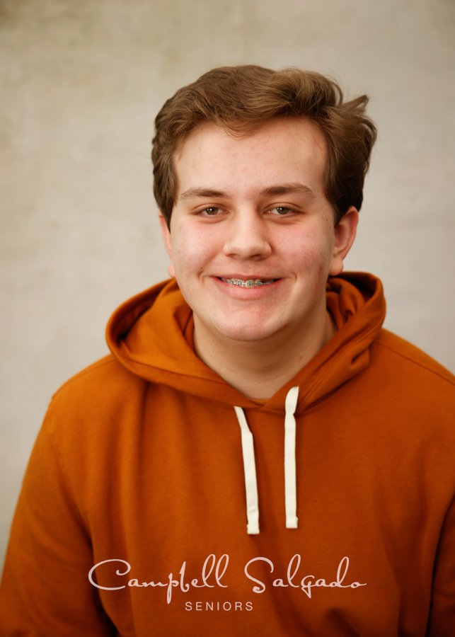  Senior photos, Portland Oregon&nbsp;of young man&nbsp;in front of a modern grey background by photographers at Campbell Salgado Studio. 