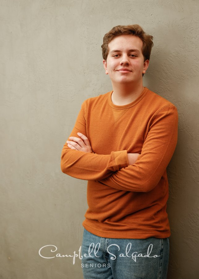  High school senior portrait photography&nbsp;of a young man standing in front of&nbsp;a modern grey background by senior photographers at Campbell Salgado Studio in Portland, Oregon. 