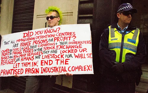 'Good point, well made', thinks nice policeman. 'Cops are tops', thinks protester. Pro-Refugee Protest by Tali Caspi/ cc