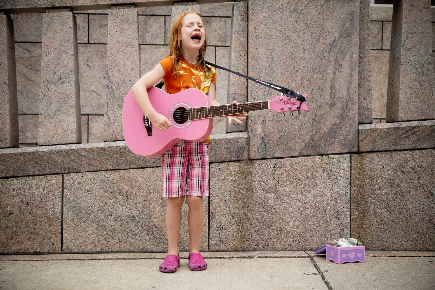 Child singing with a pink guitar Photo by Felix Koutchinski on Unsplash