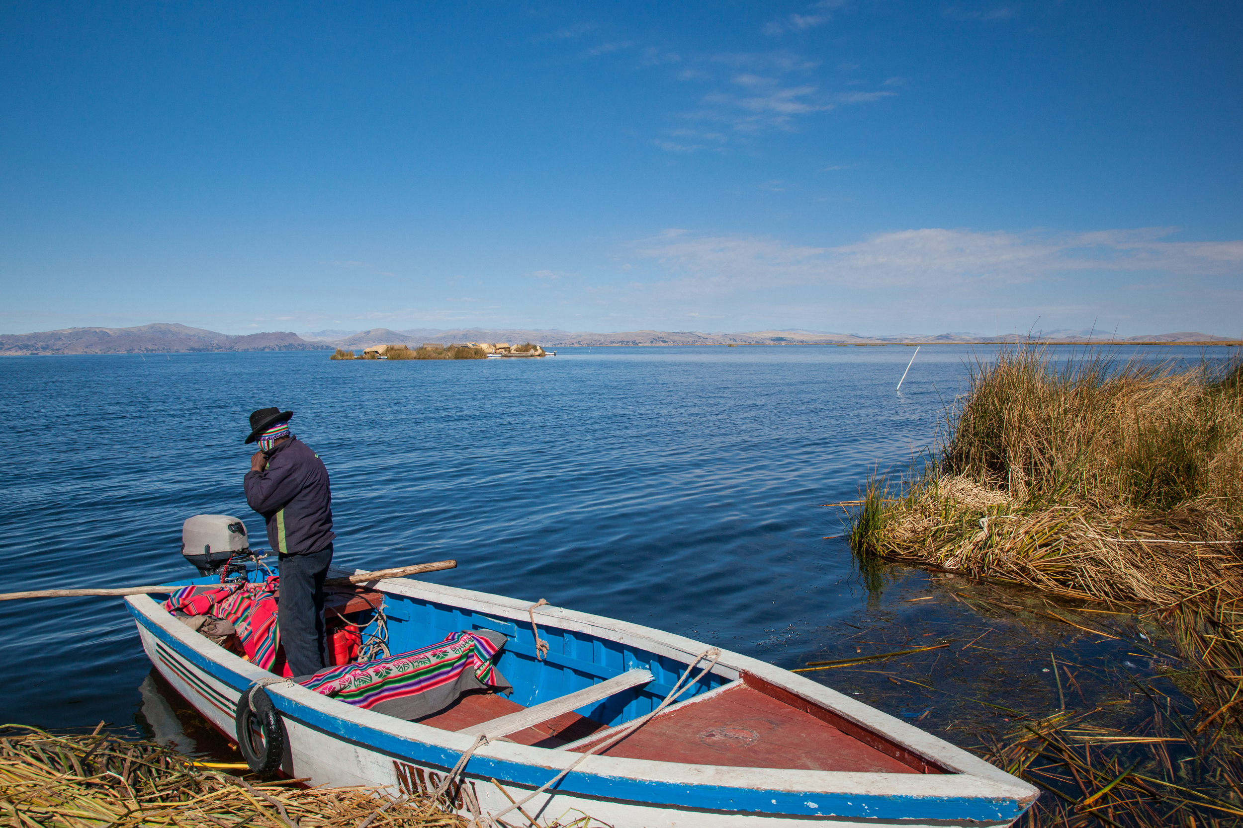 Jose and the boat that brought us to the Uros Islands. Another floating island can be seen in the distance.
