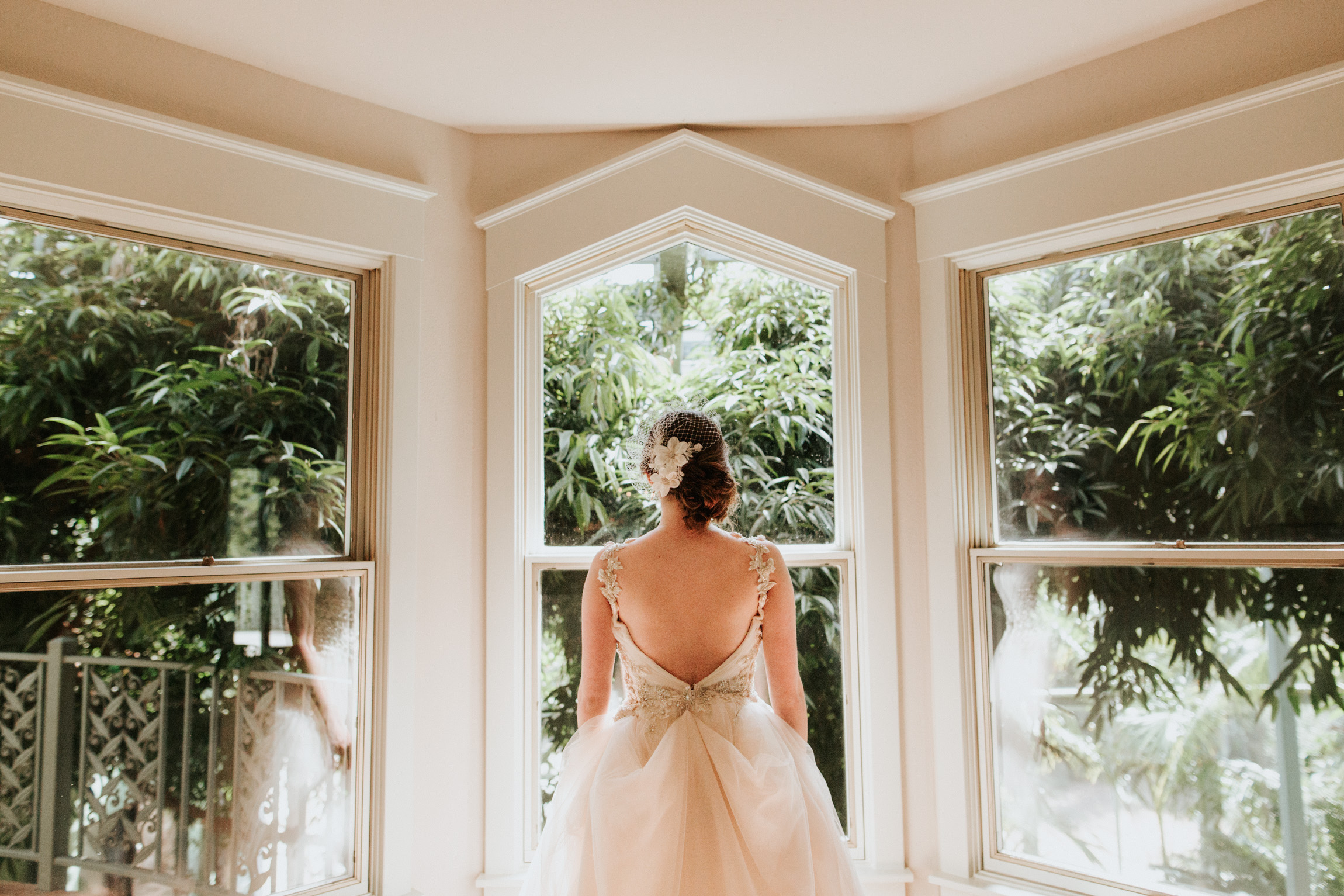 Bride looking out of the window at Greenhouse at Driftwood Wedding