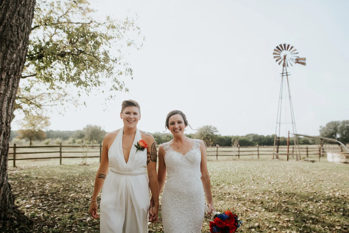 Two brides holding hands at Ranch Austin wedding