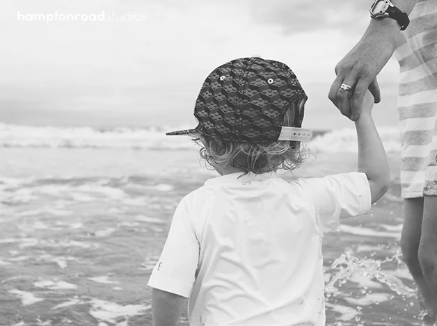 bw p holding e's hand on beach