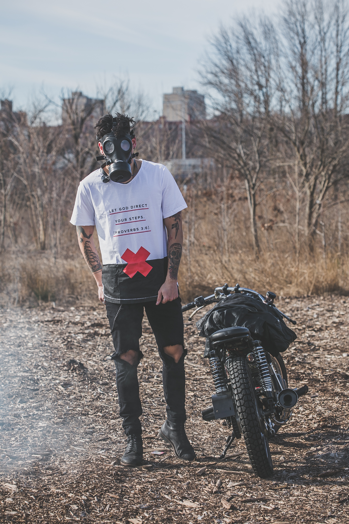 tattooed model in Anchored Apparel with motorcycle and gas mask