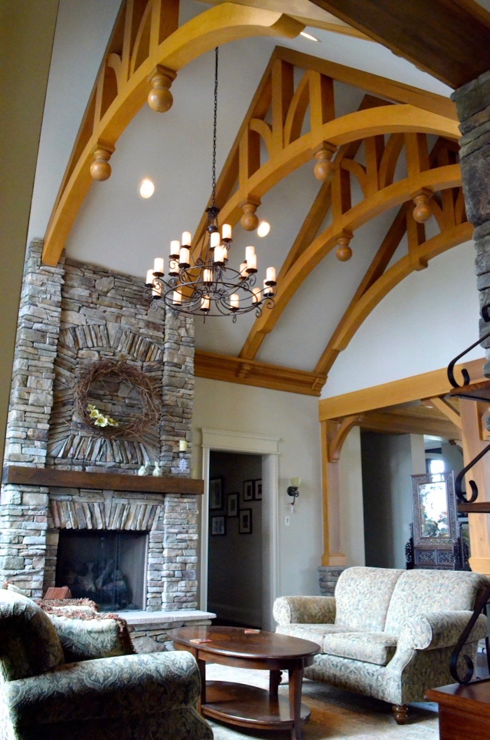 custom home decorative arched beams stone fireplace great room living room.jpeg