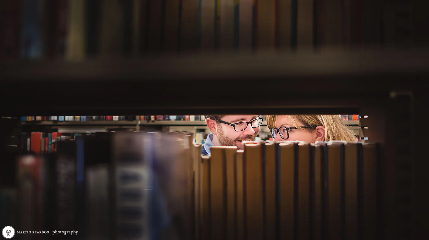 Engagement-shoot-couple-in-library-peek.jpg