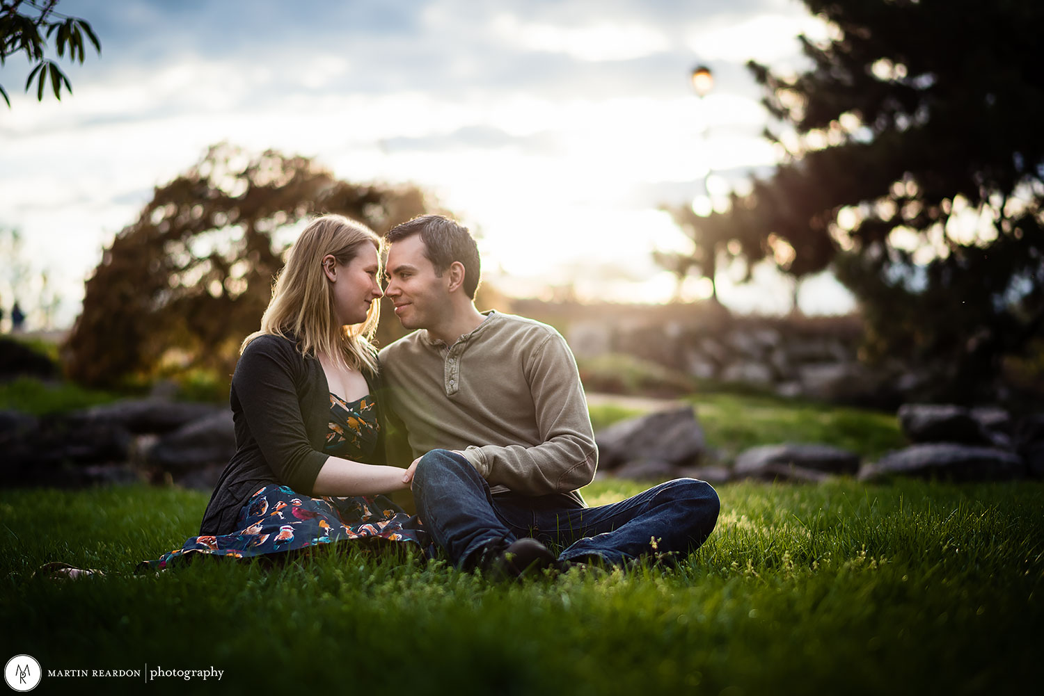 engagement photo couple sitting in grass at Philadelphia Art Museum