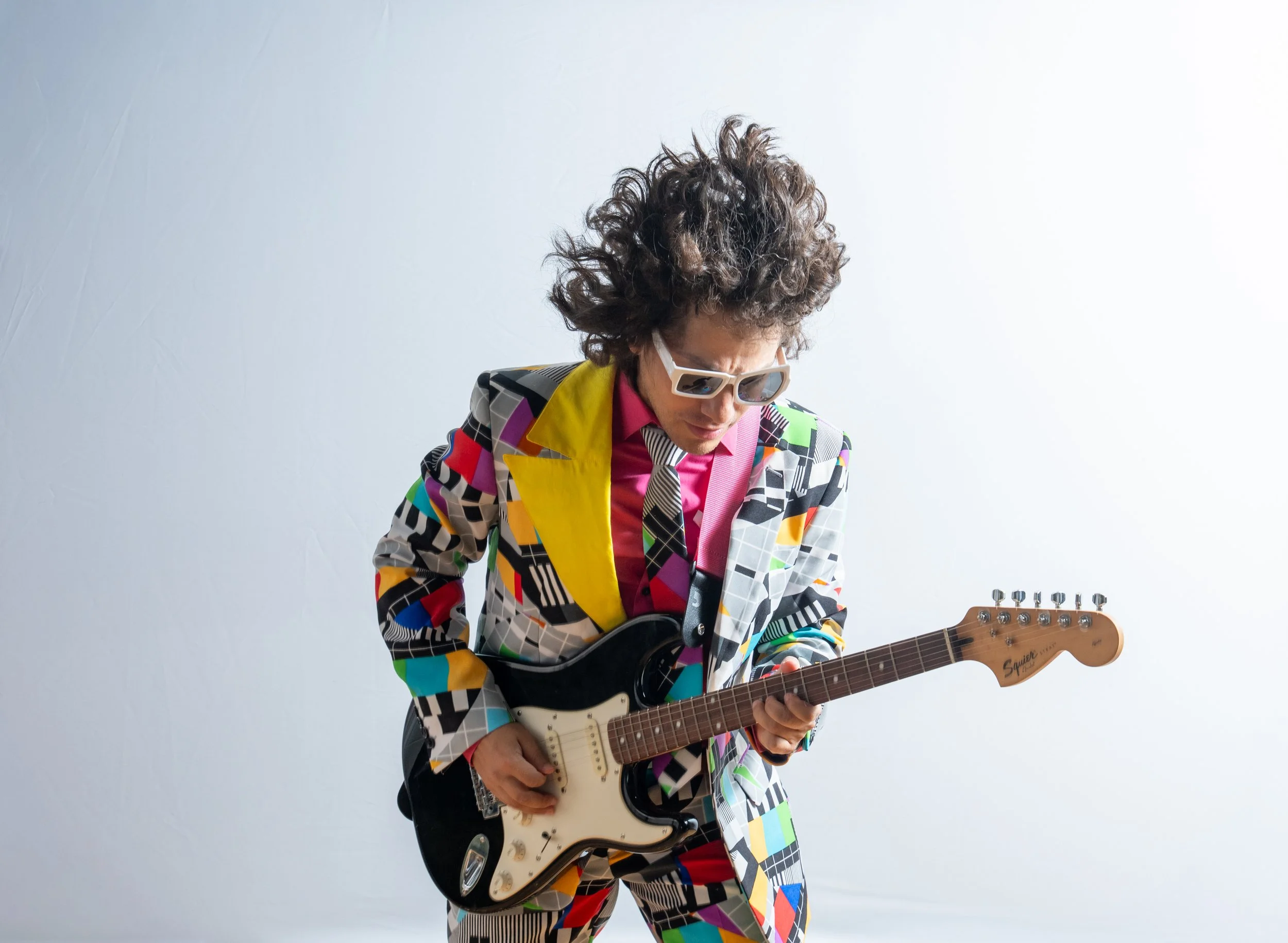 Bandleader Ace Symmetrical in his mismatched suit shreds on the guitar