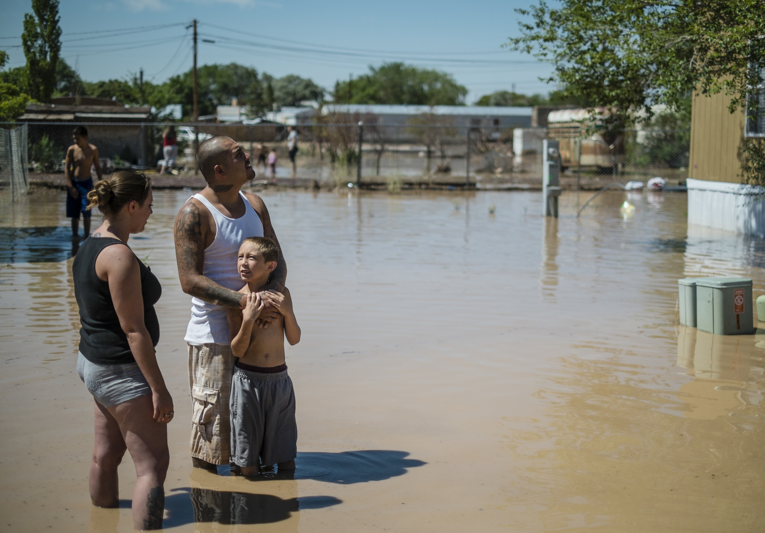 Residents of Bernalillo, New Mexico stand outside their home after being flooded by record rains.
