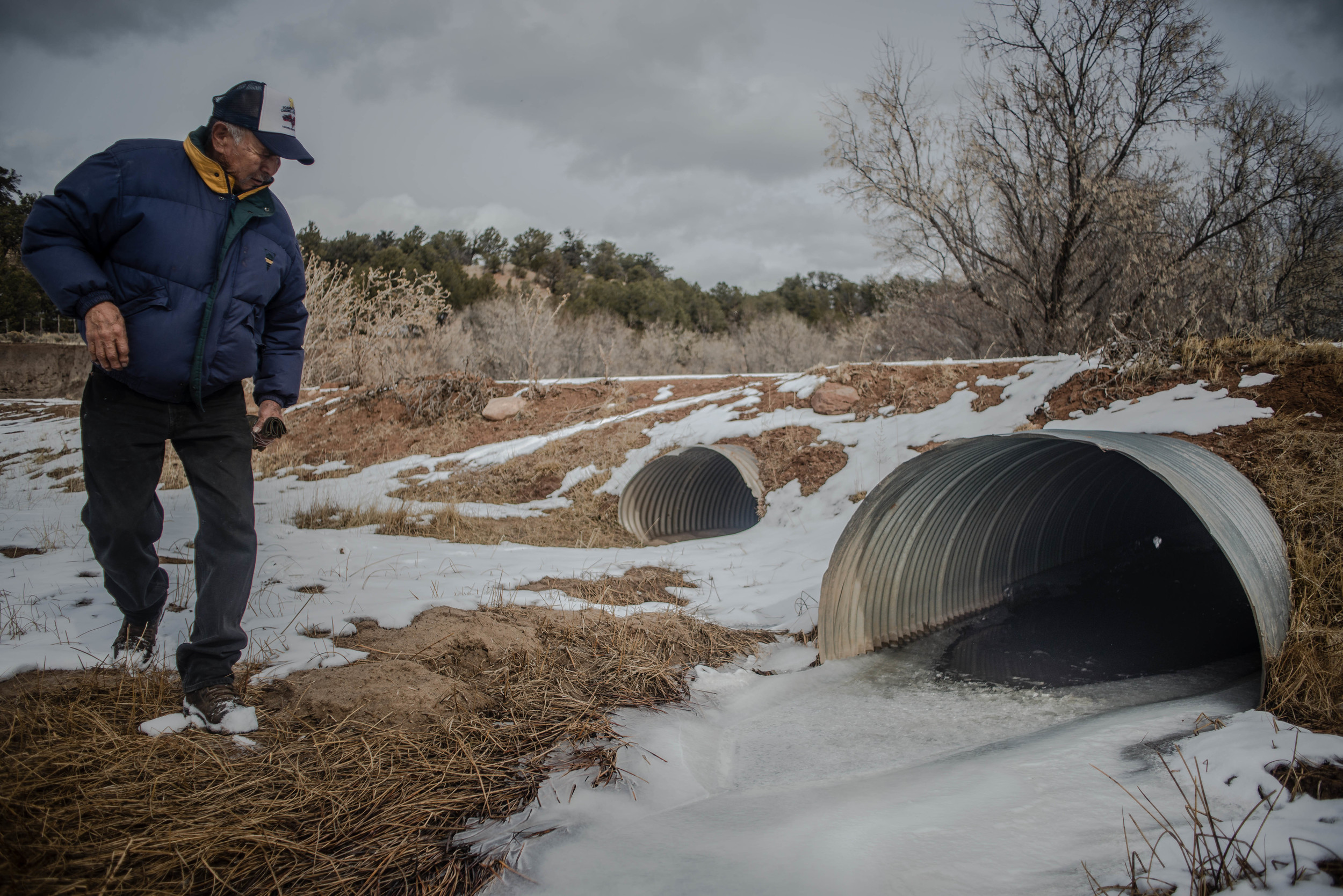 Resident Franklin Mose peers into a culvert where a 13-month-old child was found Jan. 31 in Crystal. A mother and her child were left near the culvert late at night Jan. 30 after the mother got into a fight with a woman with whom she was riding in a truck, according to the woman’s uncle. (Roberto E. Rosales/Albuquerque Journal)