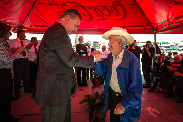 Ciudad Juárez Mayor Enrique Serrano greets resident Julio Salazar during a news conference at which officials gave away 5-gallon buckets of paint for residents to use for neighborhood improvements. (Roberto E. Rosales/Albuquerque Journal)