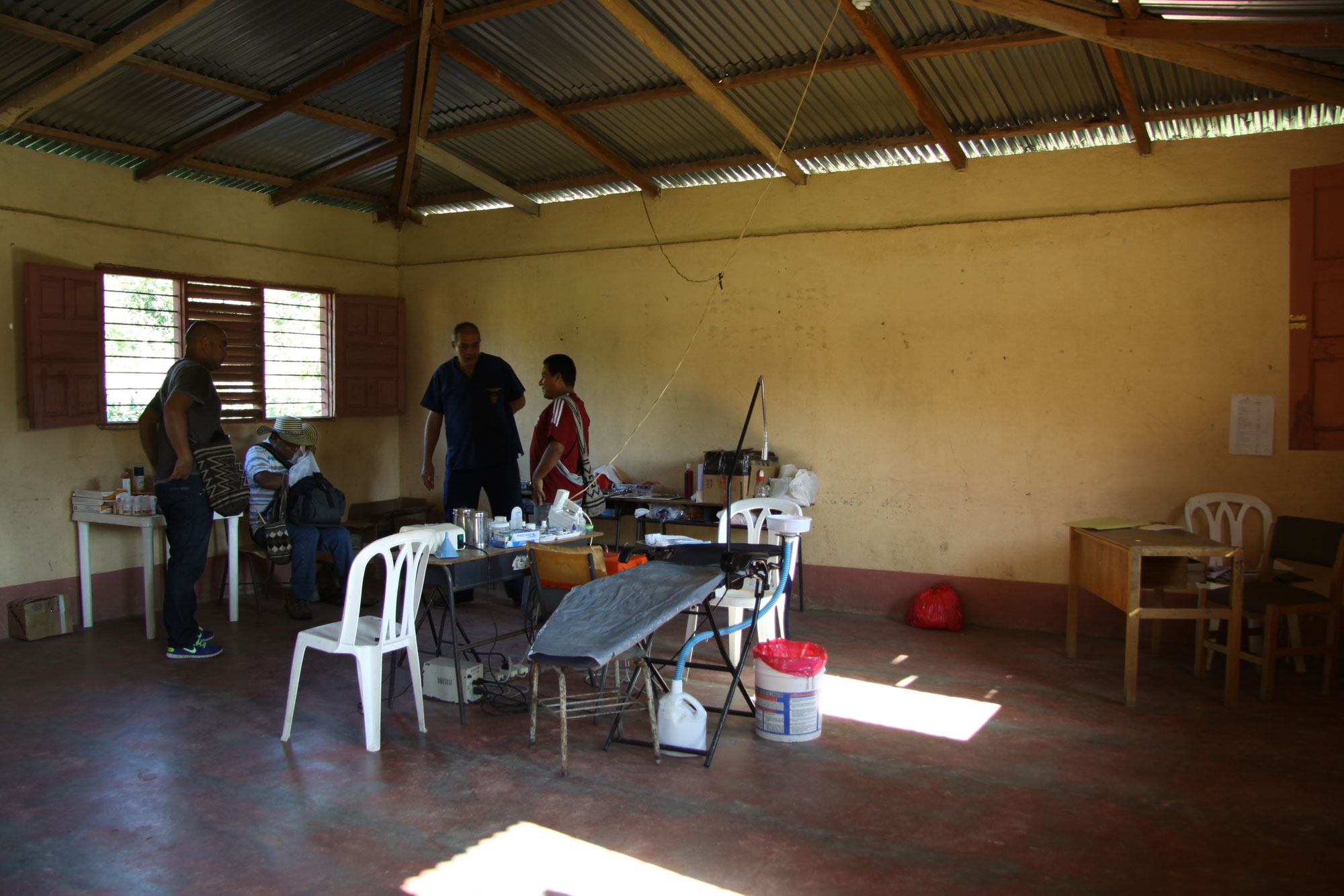 Travelling dental office set up in the school, Carlos the dentist in blue standing in the middle.