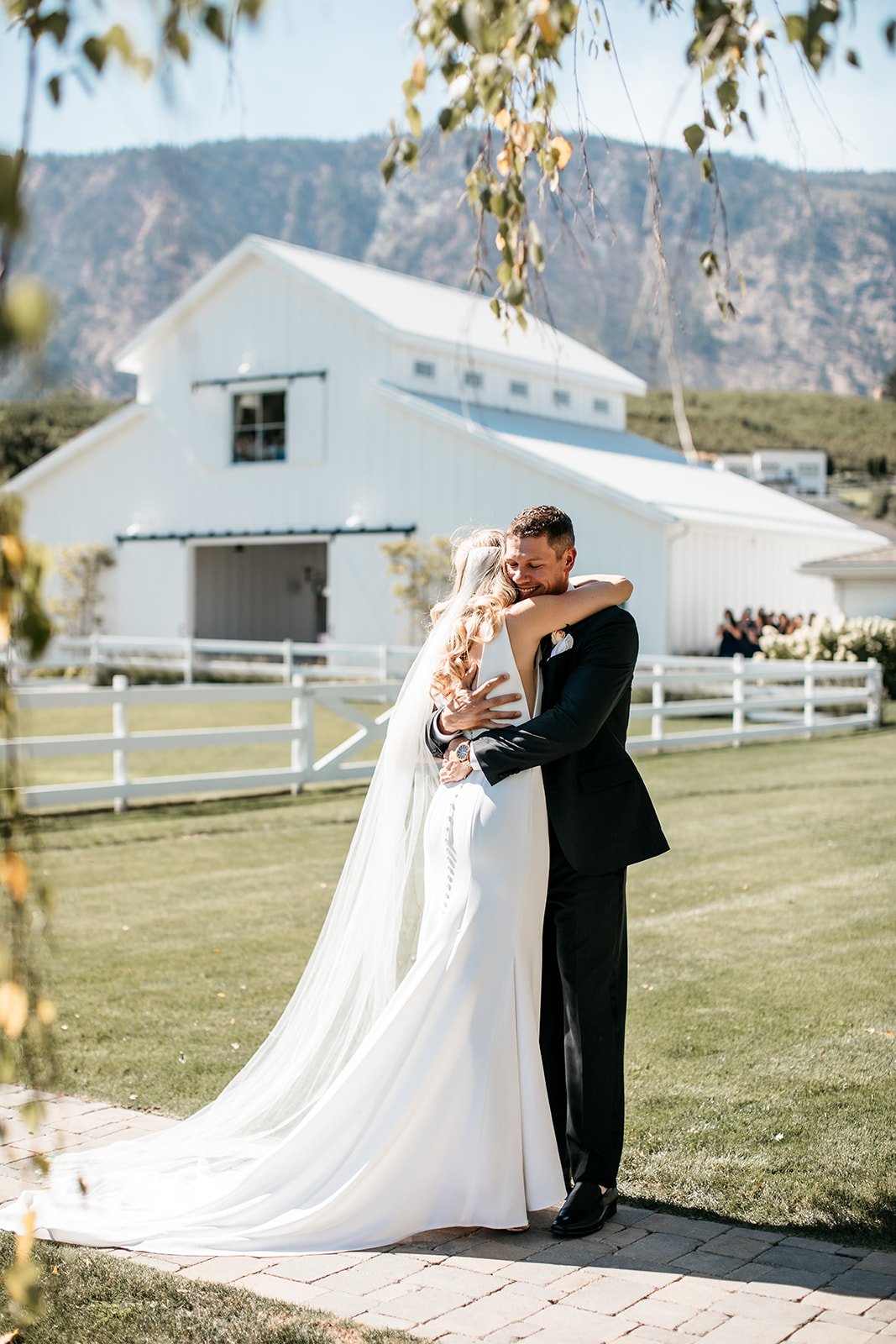  A bride wearing Alyssa Kristin Maven wedding dress embracing the groom on their wedding day at Harmony Meadows barn wedding venue near Seattle, Washington. 