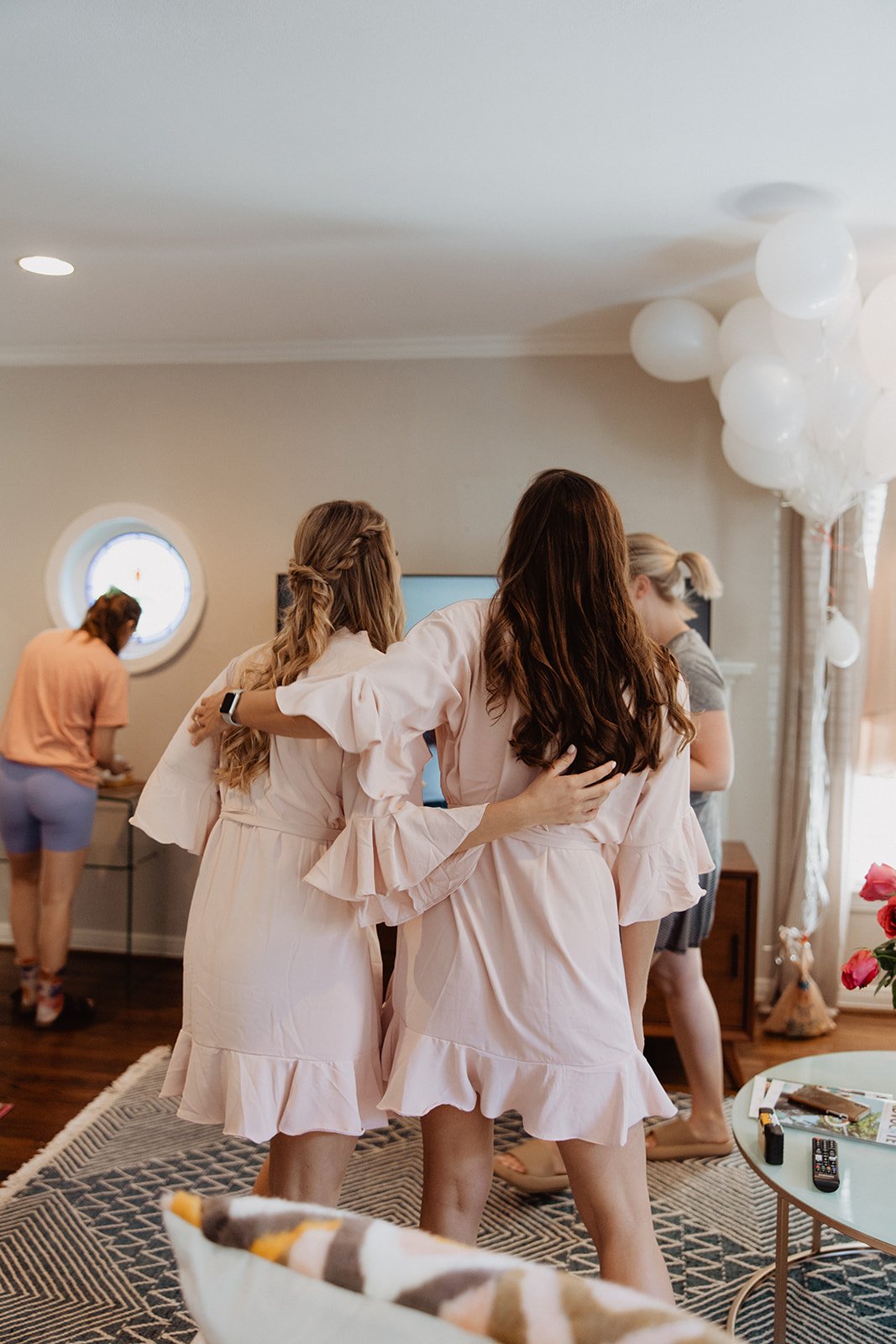  A group of bridesmaids getting ready in matching pink robes 