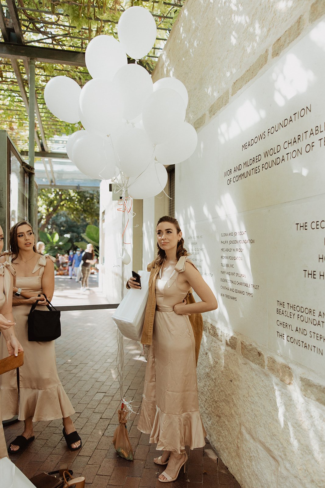  bridesmaids wearing champagne silk bridesmaids dresses with square necklines and a ruffle hem. 