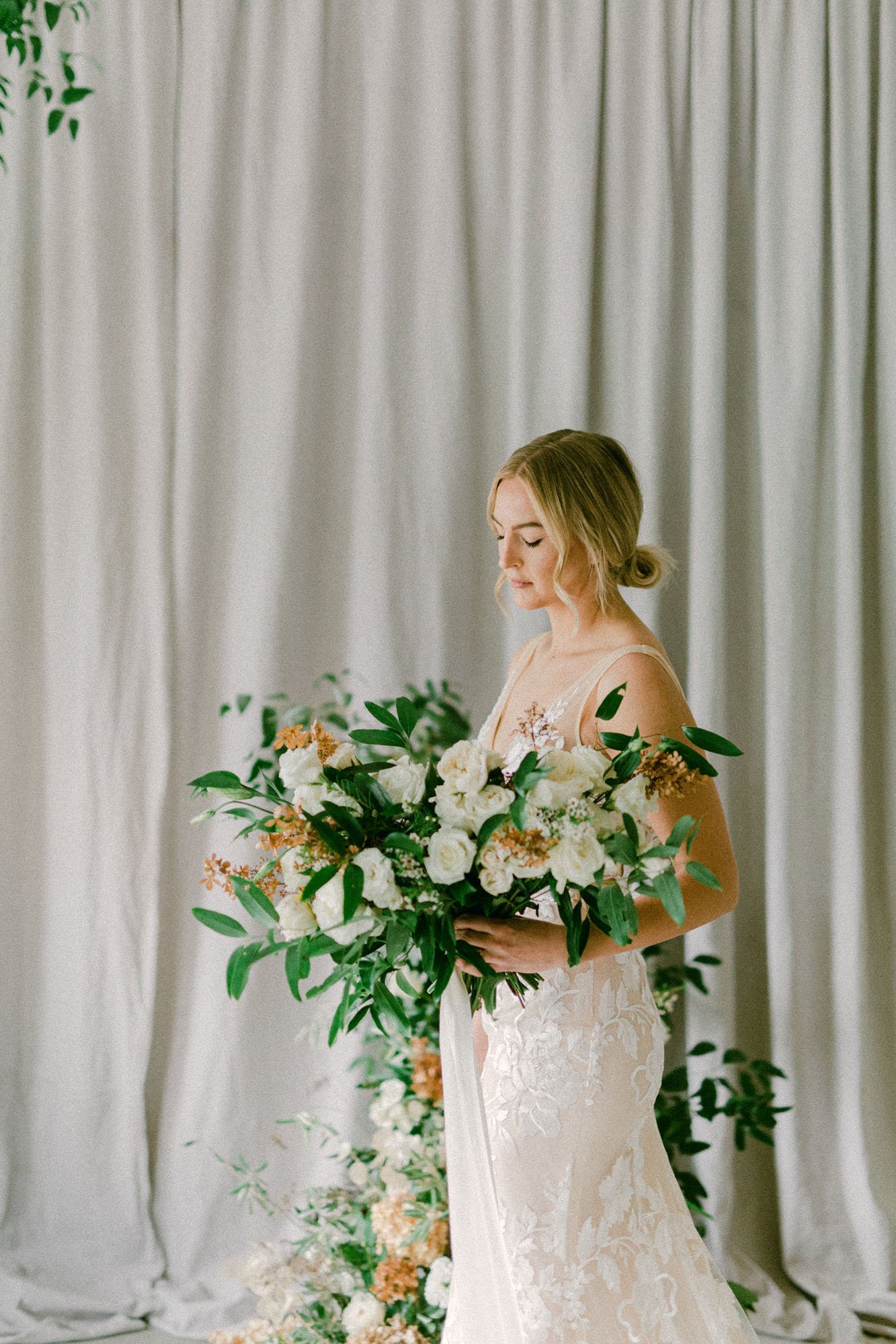  a bride wearing Elsie wedding dress by made with love bridal and holding a large organic bridal bouquet 