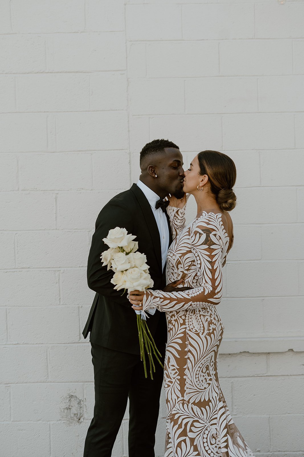  a bride wearing the reno wedding dress by rue de seine bridal sharing a kiss with the groom before their ceremony 