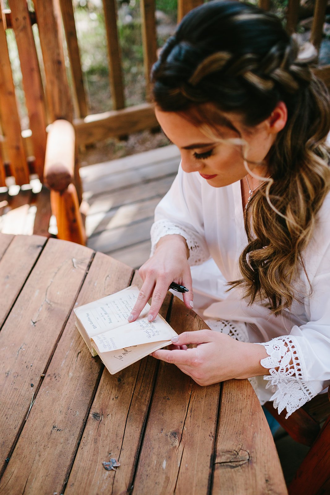  a bride writing a personal note to the groom before their wedding ceremony 