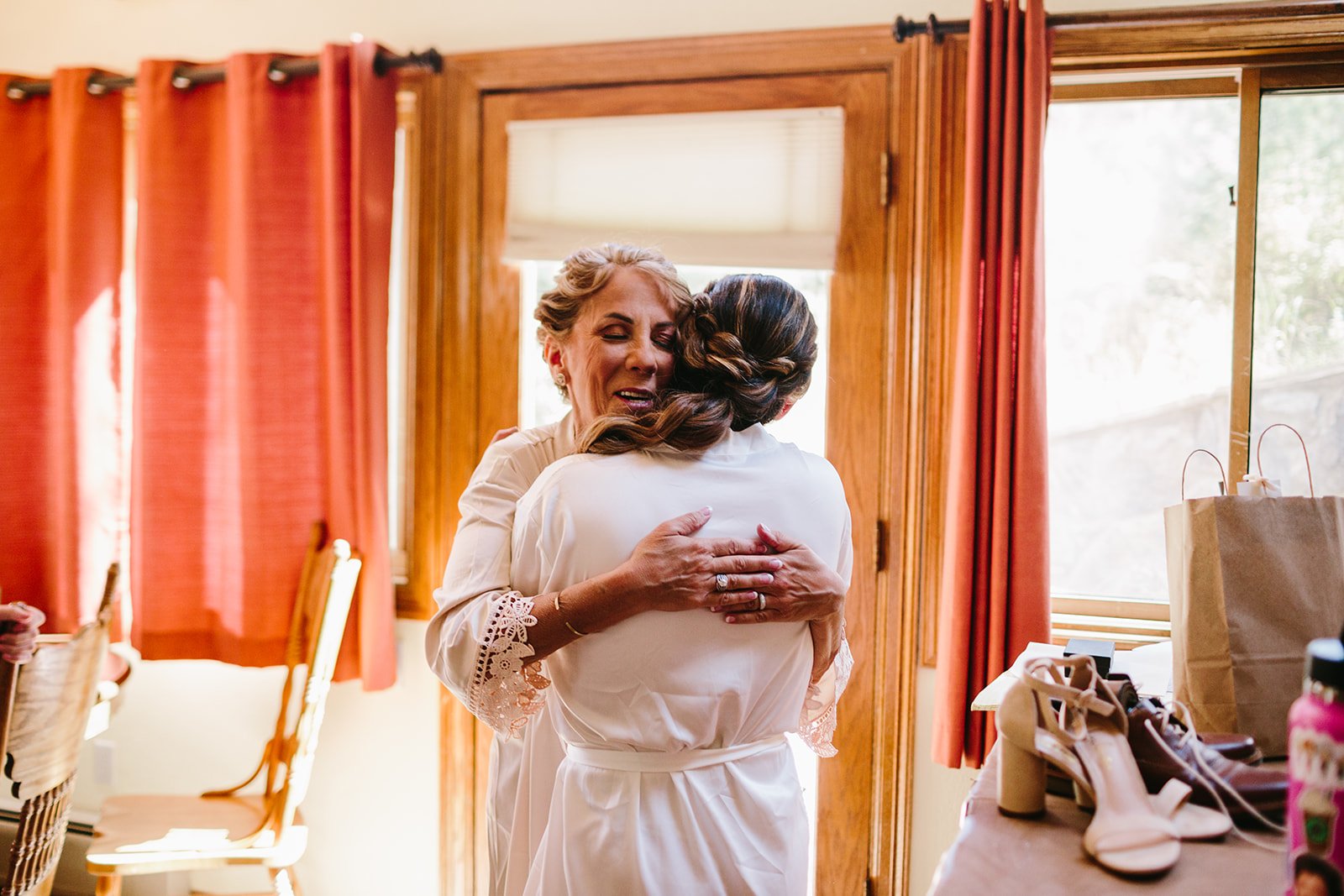  a bride hugging a loved one while getting ready for the wedding ceremony 