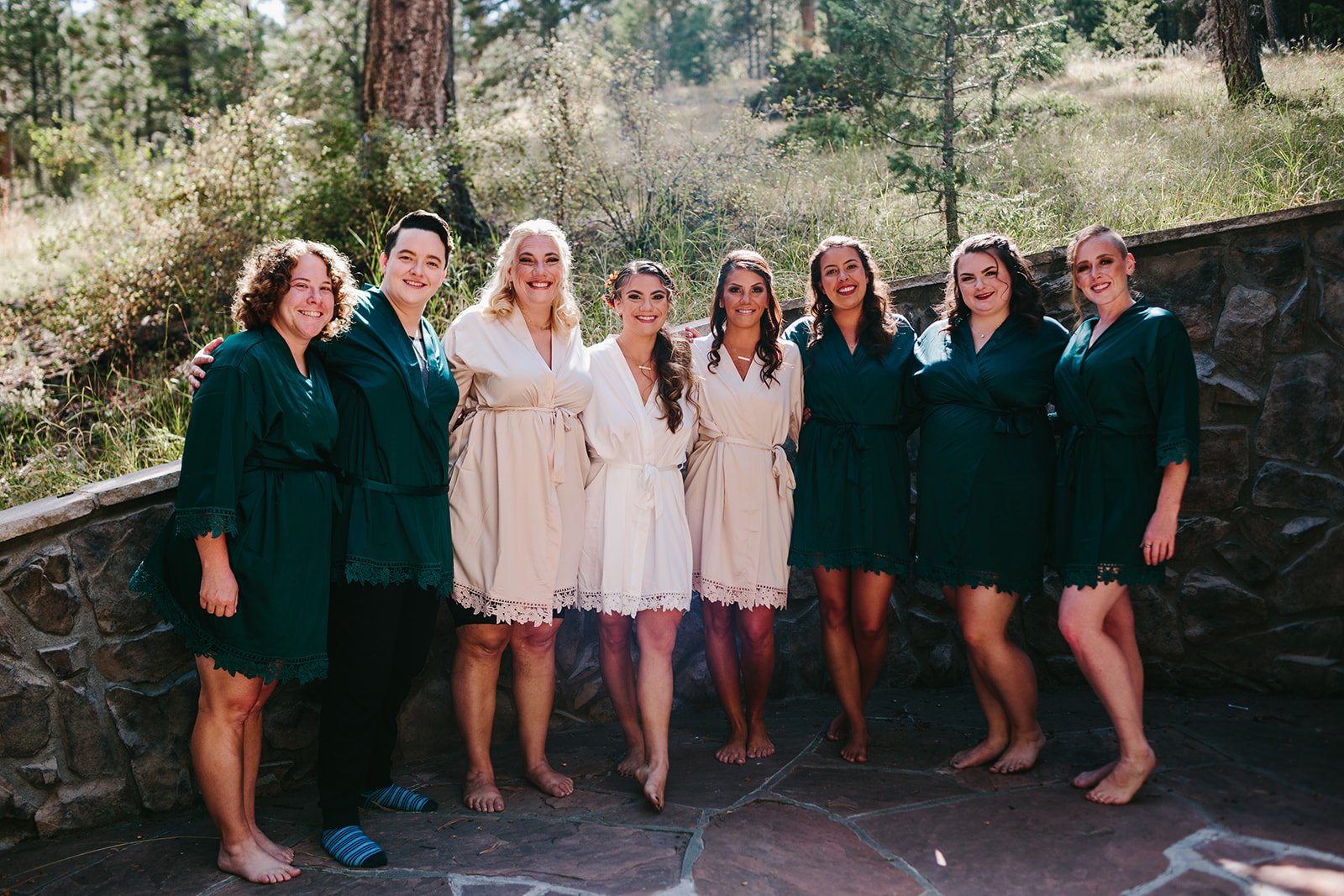  a bridal party wearing matching green and blush wedding robes 