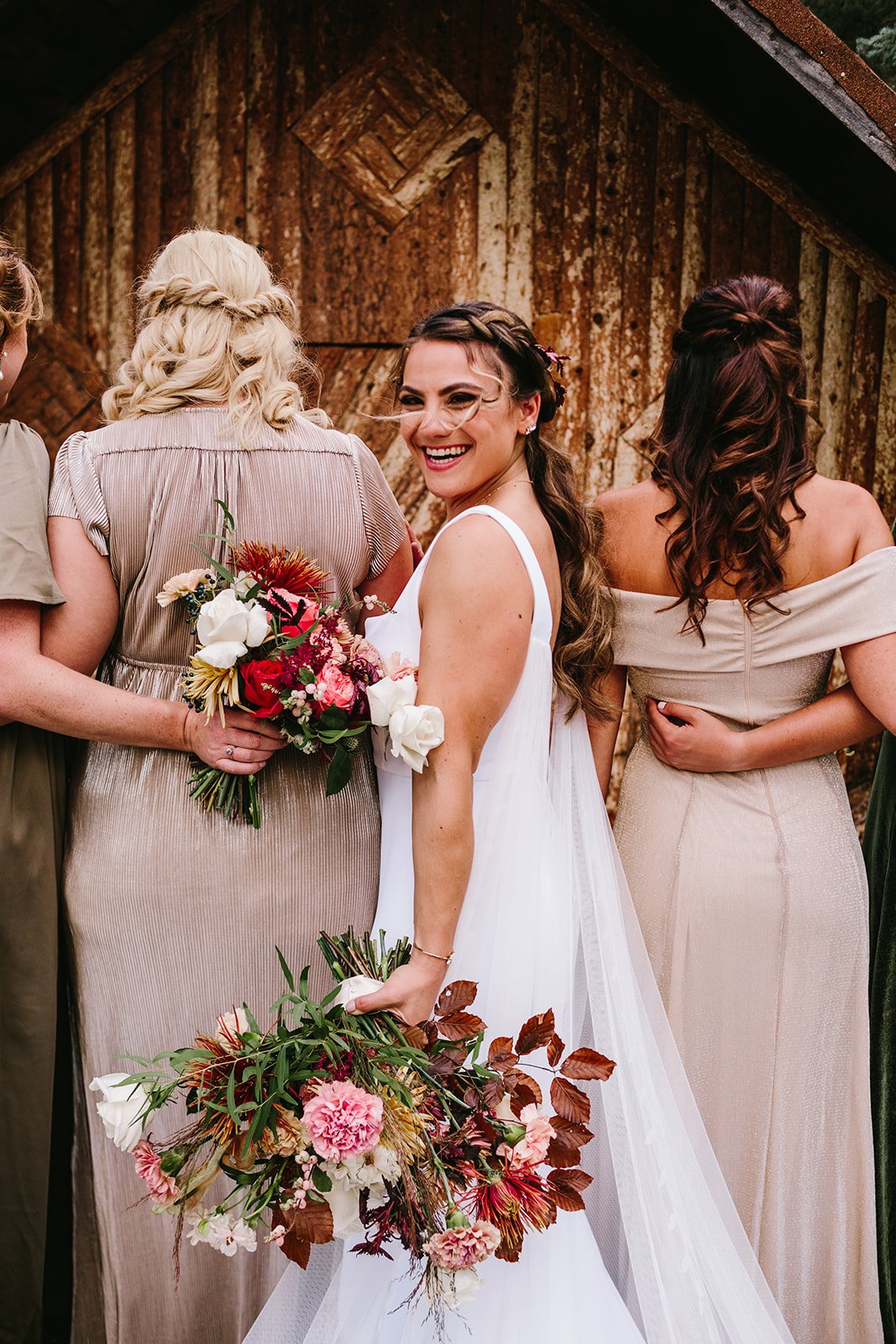  A bride wearing Alyssa Kristin Sydney wedding dress and Sara Gabriel Rachel veil holding a giant bridal bouquet full of rust and blush and white flowers 