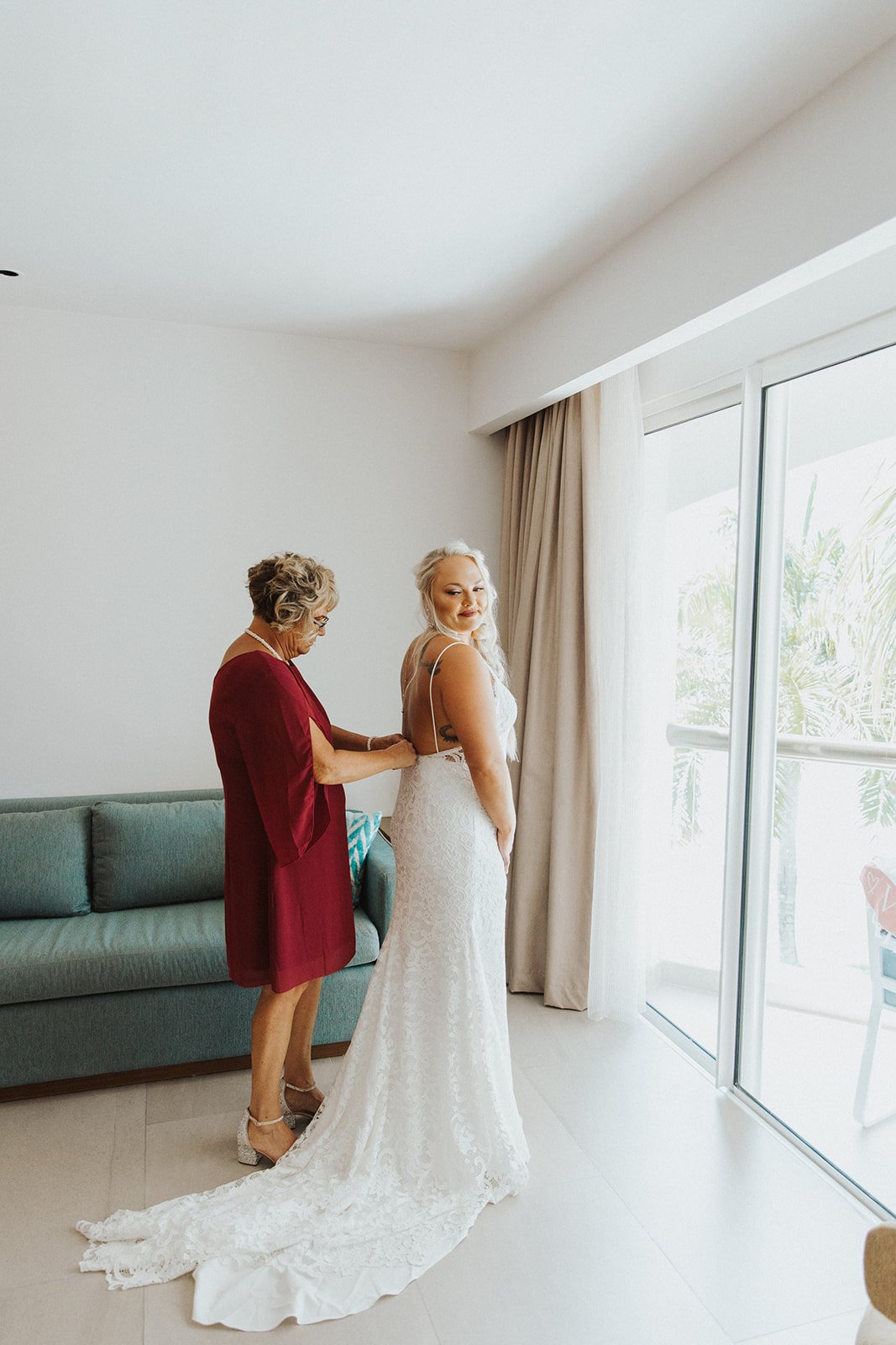  A loved one helping a bride zip into the Anais Anette ‘Emmanuelle’ wedding dress for a tropical destination wedding. 