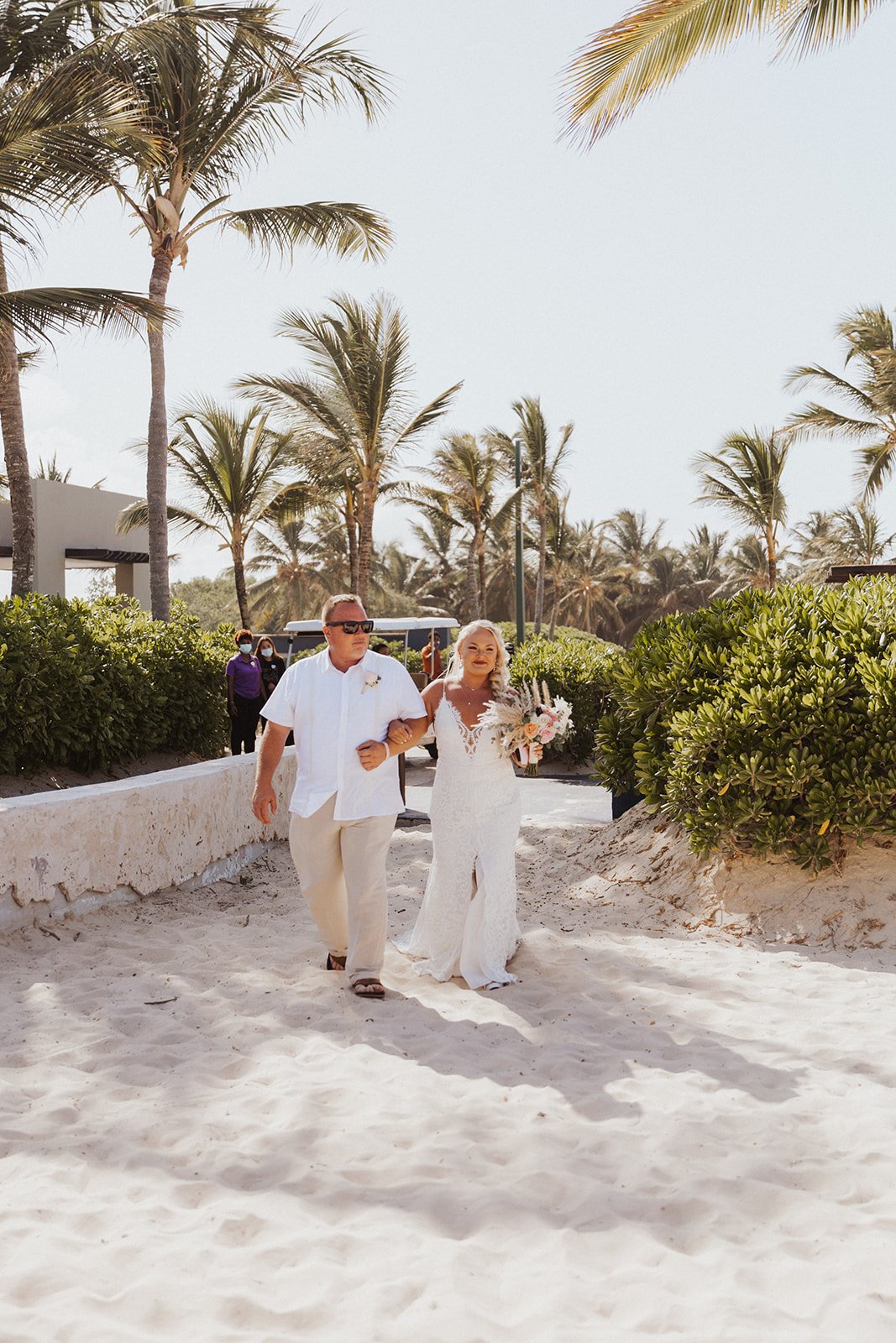  A loved one walking a bride down the beach wearing Anais Anette ‘Emmanuelle wedding dress for a lovely destination tropical wedding celebration 