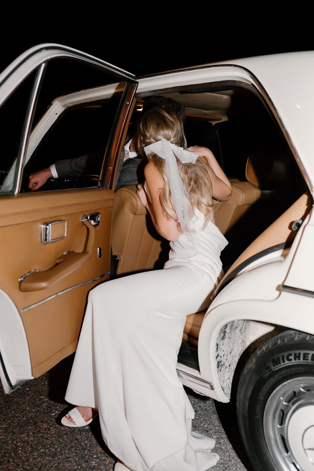 cool girl bride leaving the wedding reception in classic car wearing made with love archie wedding dress