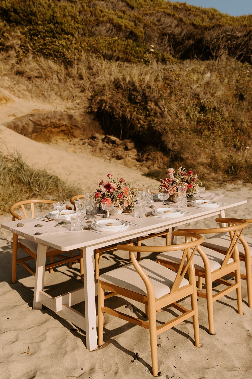 beach boho wedding inspiration featuring wishbone chairs and wild floral arrangements