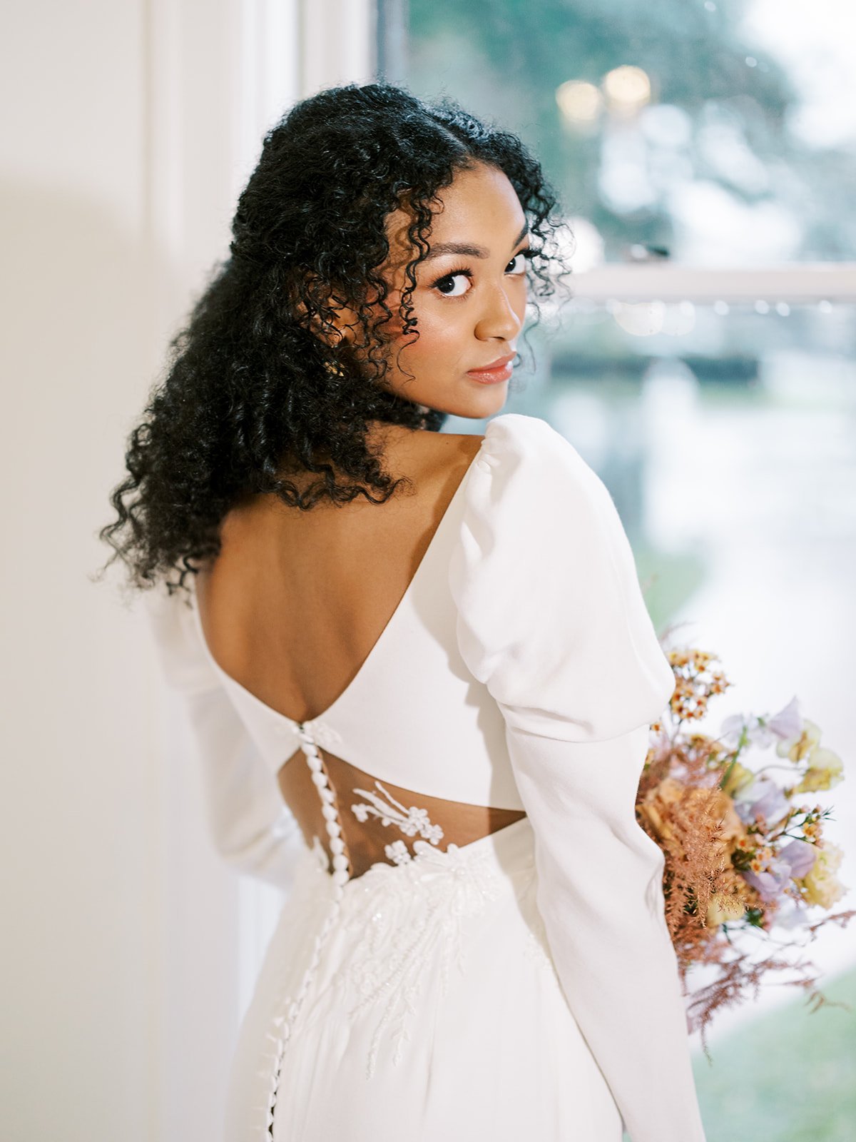 a unique romantic puff sleeve wedding dress with lace cutouts in the open back.