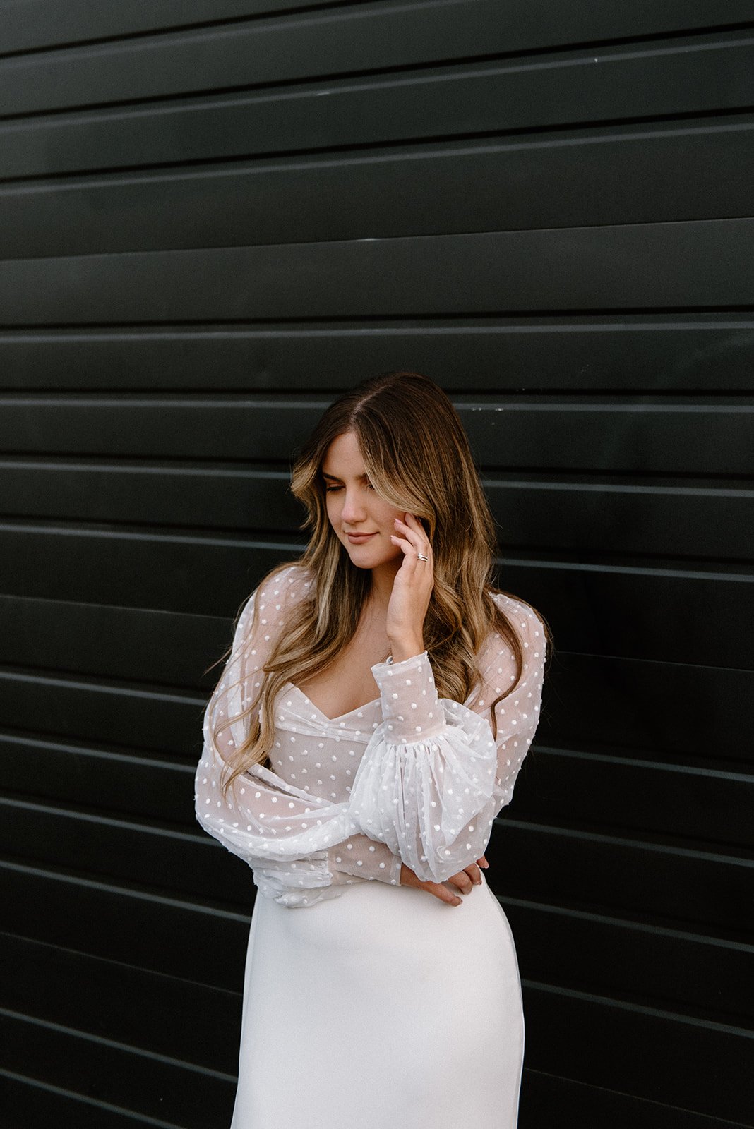 a cool sweetheart neckline sheath wedding dress styled in front of a black warehouse wall in this portland styled shoot.