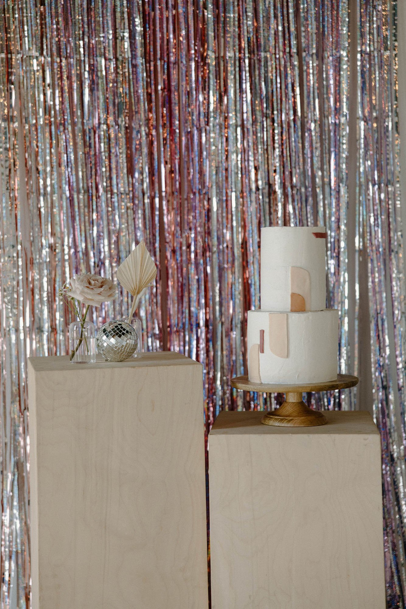 a fun holographic confetti backdrop for a modern cake at the reception at the emerson venue in texas.