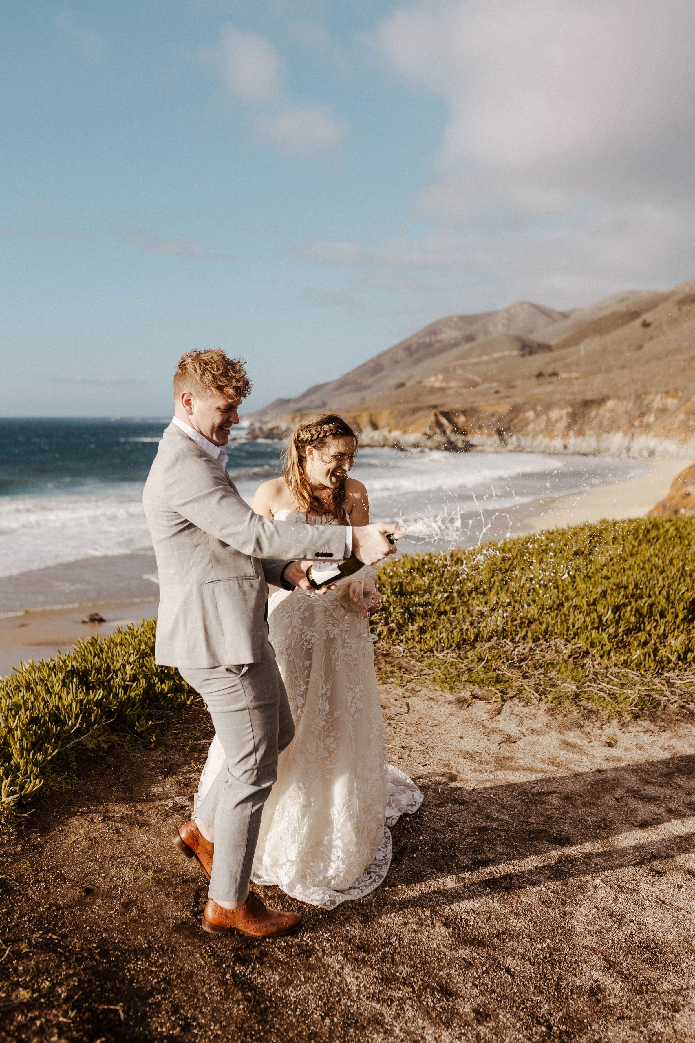 romantic bottle popping moment with the wedding couple in this oceanside elopement styled shoot