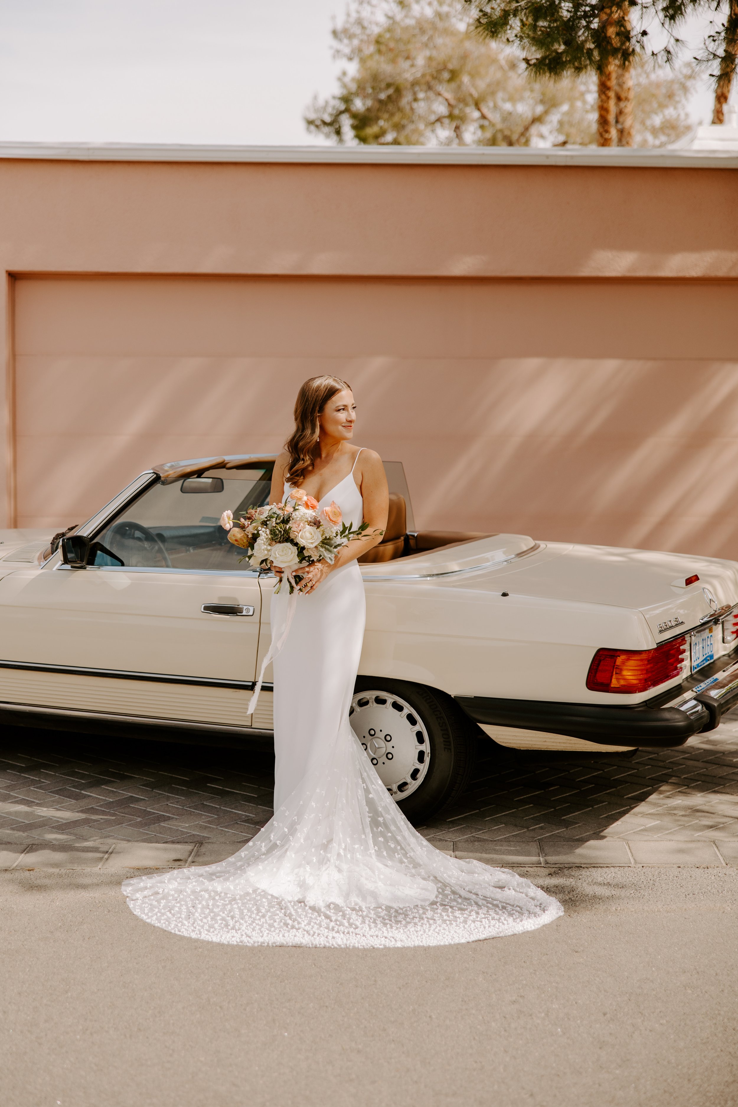 a chic and modern bridal portrait in front of a old classic car in palm springs