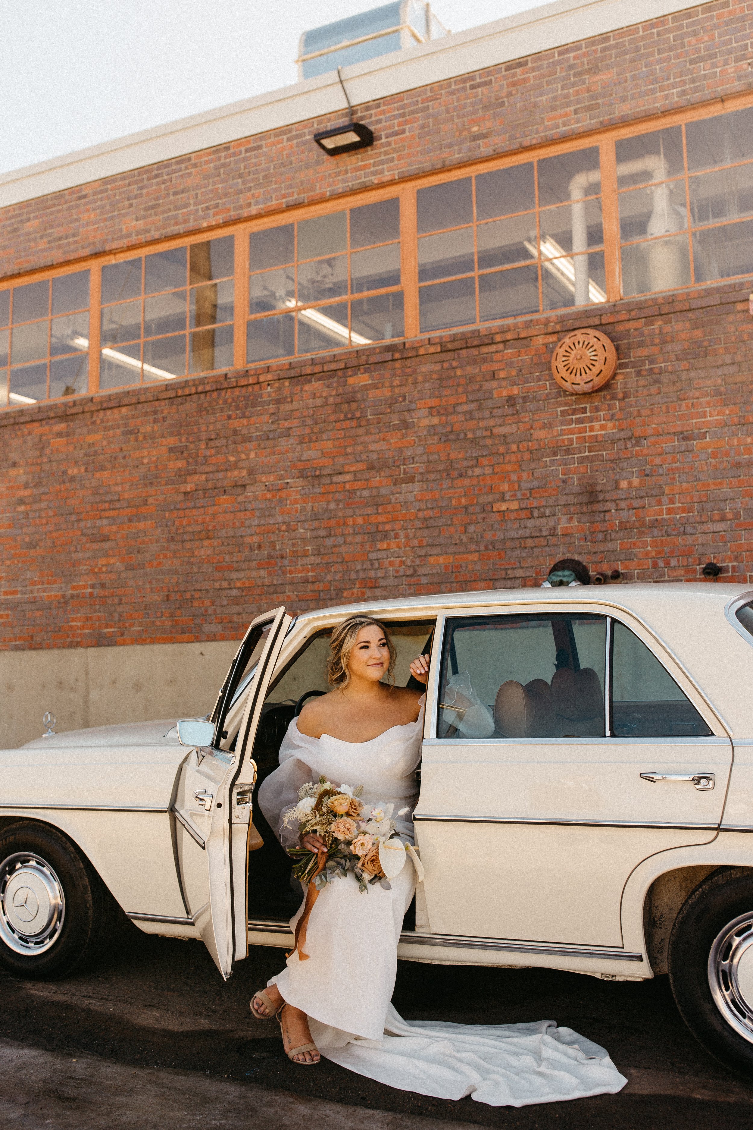 classic car photos at the end of this styled wedding shoot in an industrial setting featuring the rose wedding dress by the label