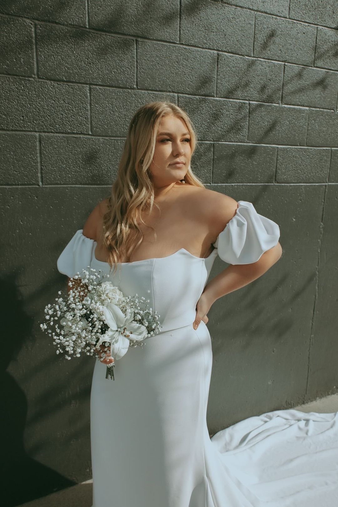 an inclusive size model wearing a puff sleeve chic crepe wedding dress by alyssa kristin