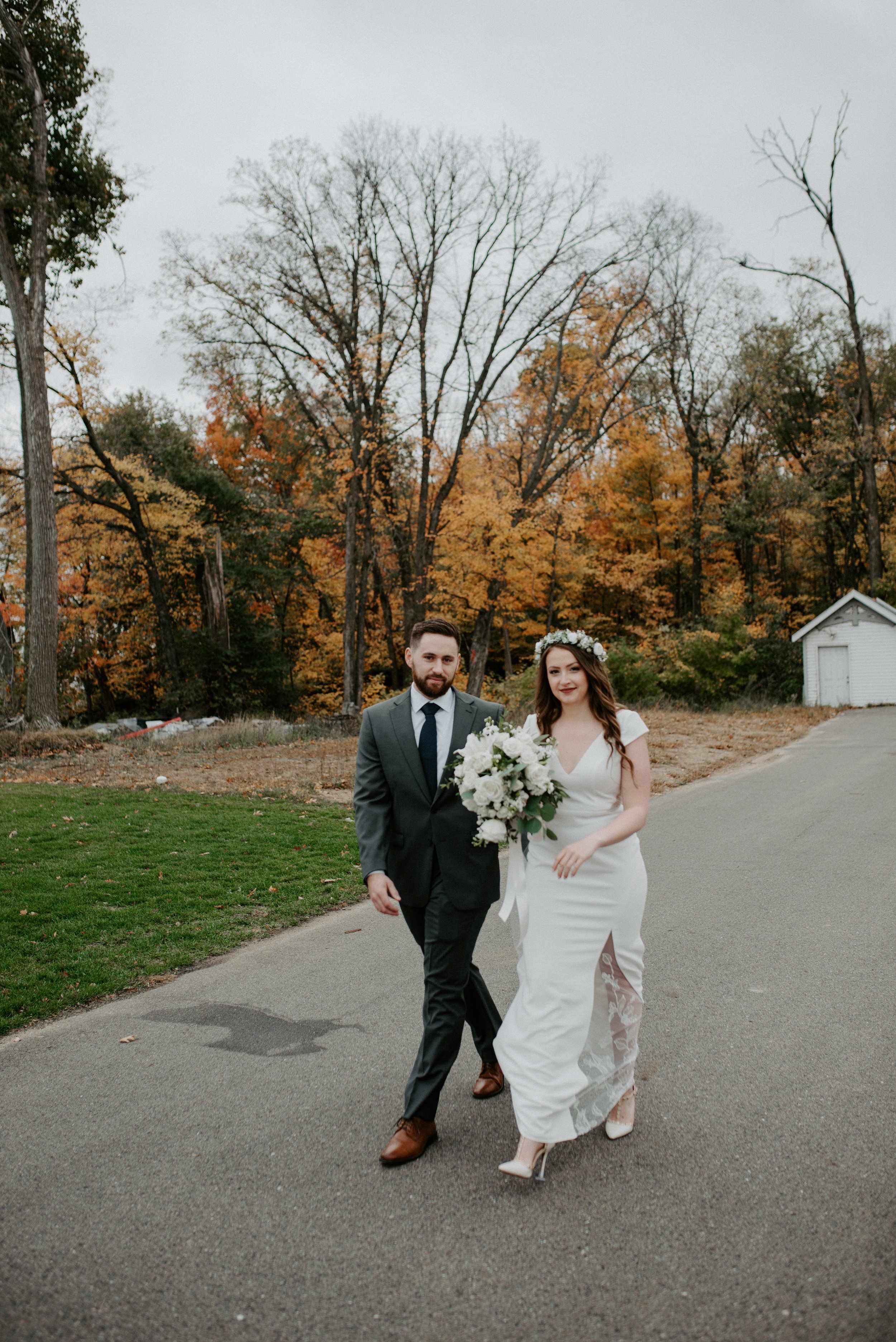 classic autumn wedding with the bride and groom walking down the street 