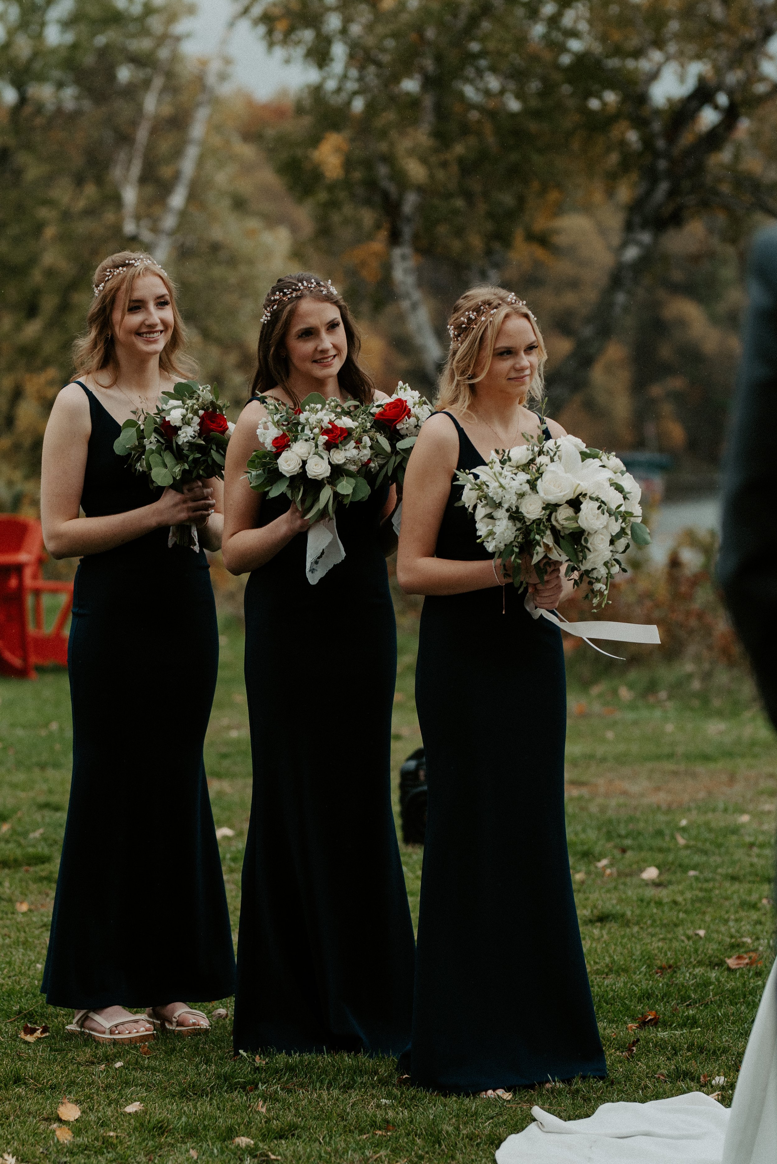 bridesmaids wearing matching black dresses and holding classic bouquets