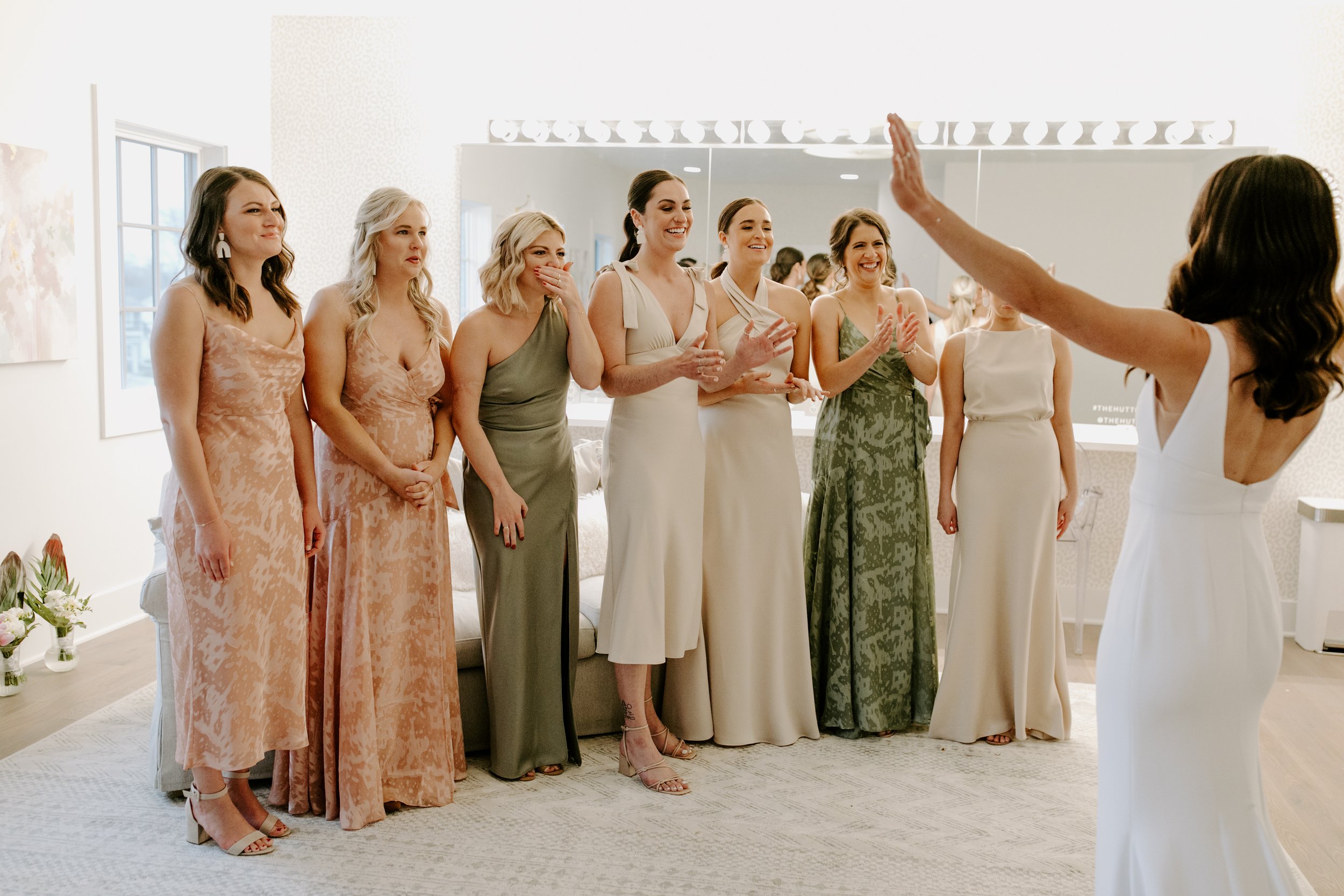the bride and her neutral tone bridesmaids in thier first look pictures