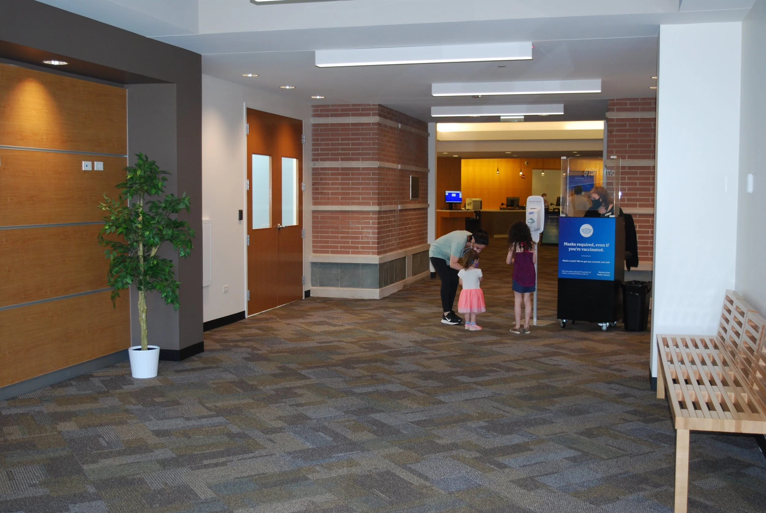 photograph of one adult and two children follwing instructions on a safety sign